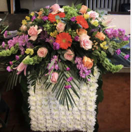 Large funeral spray with pink roses, gerbera daisies, and white chrysanthemums