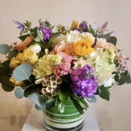 Mixed bouquet of pastel flowers in a striped glass vase