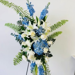 Tall blue and white floral standing arrangement on an easel