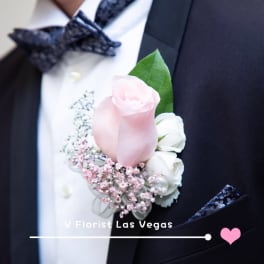 Pink and white boutonniere on a black suit jacket