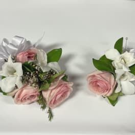 Pink rose and white gardenia wrist corsage and boutonniere set on white background