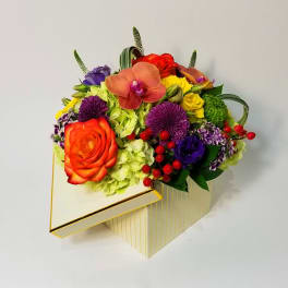 Colorful mixed flower arrangement in a gold-striped box