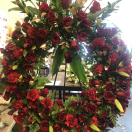 Large red rose and carnation wreath on a stand