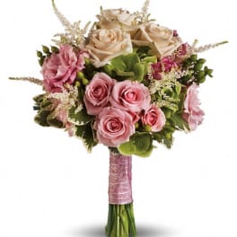 Pink and cream rose bouquet with green accents and a pink wrapped handle