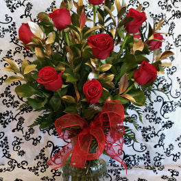 Bouquet of red roses in a glass vase with a red ribbon