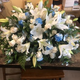 Large white lily and rose arrangement with blue carnations