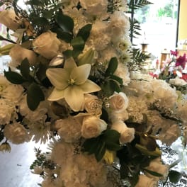 White floral arrangement with roses, lilies, and carnations