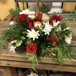 Holiday floral centerpiece with red roses, white daisies, and gold ornaments