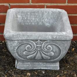 Empty gray stone planter with decorative scrollwork