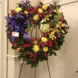 Large heart-shaped sympathy wreath with mixed flowers on an easel