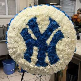 Round floral tribute with a blue and white monogram design