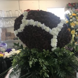 Large heart-shaped floral tribute with white flowers and dark blooms