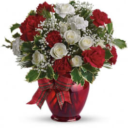Red and white rose bouquet in a red glass vase with a plaid ribbon