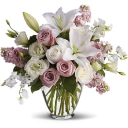 Pink and white bouquet with lilies and roses in a glass vase