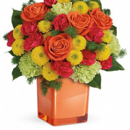 Bouquet of orange roses, red carnations, and yellow mums in an orange vase