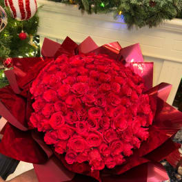 Large bouquet of red roses wrapped in glossy red paper