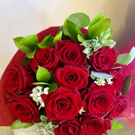 Bouquet of red roses with green foliage and small white filler flowers