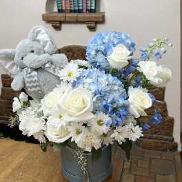 Blue and white flower arrangement with a plush elephant in a hatbox
