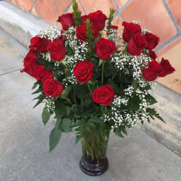 Bouquet of red roses and white baby's breath in a glass vase