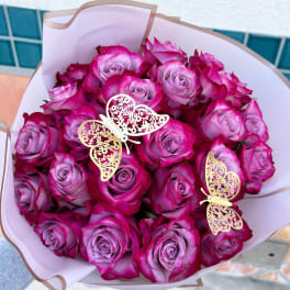 Bouquet of pink and lavender roses with butterfly decorations