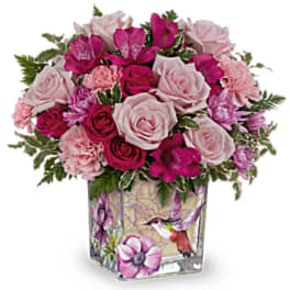 Pink and magenta roses arranged in a decorated glass vase
