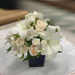 White floral arrangement in a dark square vase