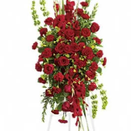 Tall standing arrangement of red roses and greenery on a white easel