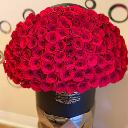 Large dome of red roses arranged tightly in a black hat box