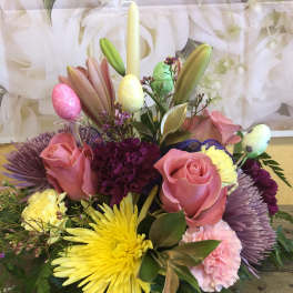 Pink roses and yellow chrysanthemums arranged with pastel Easter eggs