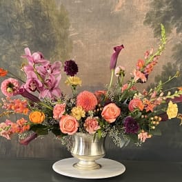 Colorful floral arrangement in a silver pedestal vase