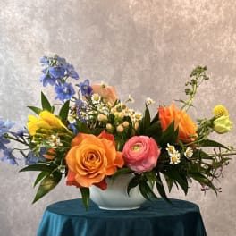 Colorful mixed flower arrangement in a white bowl vase