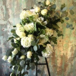 White floral spray with roses and hydrangeas on a stand