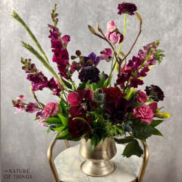 Tall mixed bouquet in a silver vase with burgundy and pink flowers
