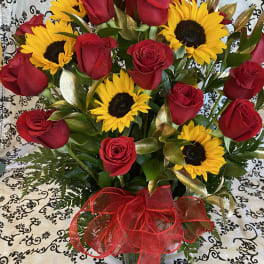 Bouquet of red roses and yellow sunflowers with a red ribbon
