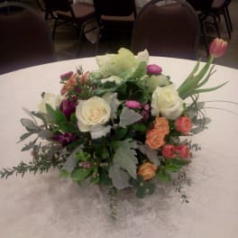 Low floral centerpiece with roses and tulips on a round table