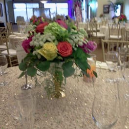 Round centerpiece of multicolored roses on a banquet table