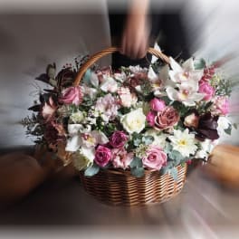 Basket of pink and white mixed flowers with orchids and roses