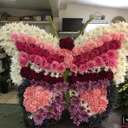 Large butterfly-shaped floral arrangement with pink, white, and purple flowers