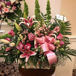 Large pink floral basket with lilies, roses, and a pink ribbon