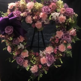 Heart-shaped floral wreath with purple roses and pink carnations