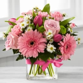 Pink mixed bouquet in a clear glass vase with a ribbon
