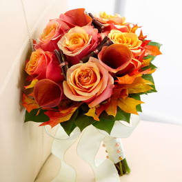 Bouquet of orange and peach roses with calla lilies and autumn leaves