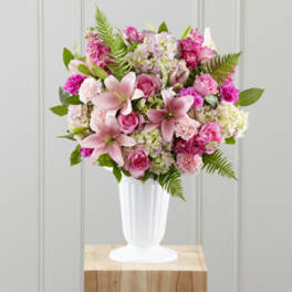 Pink mixed flower arrangement in a white vase