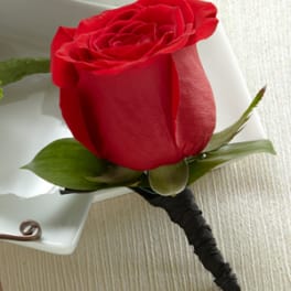 Single red rose boutonniere with white ribbon wrap