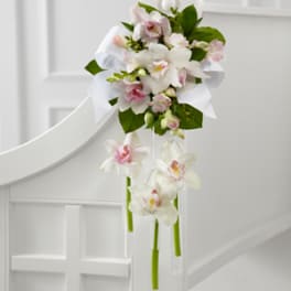 White and pink orchid bouquet with trailing stems and a white ribbon