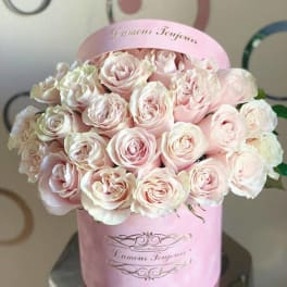 Round pink hat box filled with pale pink roses