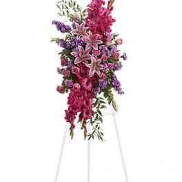 Tall floral spray with pink lilies and purple flowers on a stand