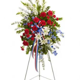 Standing floral spray with red, white, and blue flowers on an easel