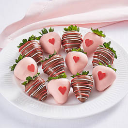 Plate of chocolate-covered strawberries with pink and red heart decorations