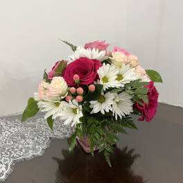 Bouquet of pink and white roses with white daisies in a pink vase